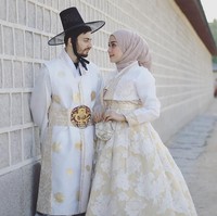 Model berhijab, Hamidah Rachmayanti menghabiskan bulan madu bersama sang suami Irvan Farhad. Mereka tampak kompak memakai busana tradisional Korea berwarna senada. Foto: Instagram