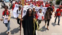 Salah seorang buruh berperan sebagai iblis jahat yang mengikat buruh tani, pedagang kecil, pelamar kerja, ibu rumah tangga hingga buruh pabrik.