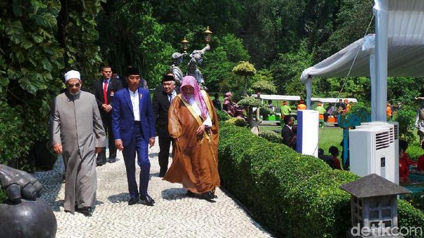 Jokowi duduk bersebelahan dengan Ahmad Muhammad dan saling berbincang.