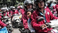 Seorang ayah membonceng anaknya saat mengikuti aksi May Day.
