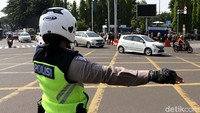 Polisi mengatur lalu lintas.
