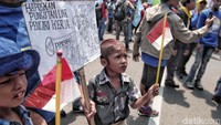 Seorang anak membawa bendera Merah Putih.