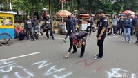 Para vandal itu corat-coret aspal jalan di depan Gedung Sate menggunakan pylox cat putih dan hitam. (Foto: Tri Ispranoto/detikcom).