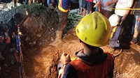 Para petugas yang melakukan evakuasi terpaksa membuat lubang baru. Lantaran lubang tempat korban terjatuh sudah tertimbun.  (Eva Safitri/detikcom)