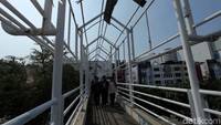 Warga melintas di JPO Jalan Mangga Dua Raya, Jakarta Utara yang sudah tidak beratap.