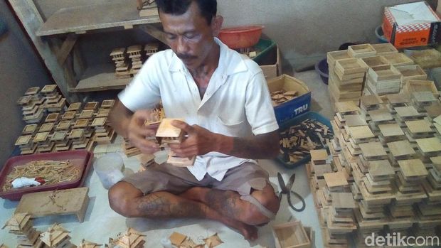 Hariyanto saat mengerjakan miniatur Menara dan rumah adat Kudus.