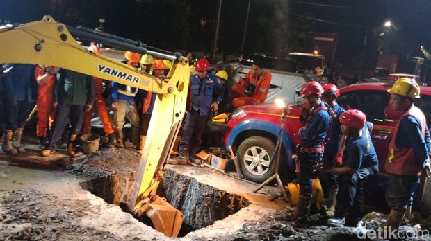 Petugas menggunakan ekskavator saat mengevakuasi Tarno yang tertimbun tanah