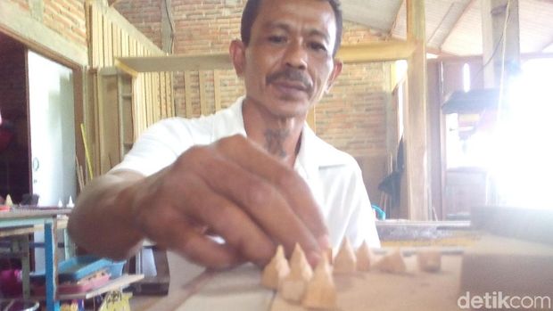 Hariyanto saat mengerjakan miniatur Menara dan rumah adat Kudus.