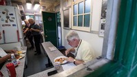 Di dalam shelter ini ada meja kecil berbentuk U yang biasa digunakan untuk makan. Biasanya ada sekelompok supir taksi yang menyeruput teh hingga makan telur orak-orik juga sosis (BBC Travel)