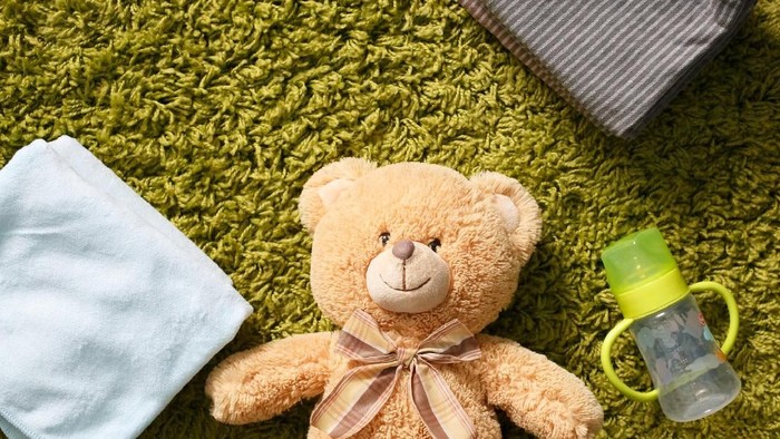 Baby accessories and toy on the green carpet