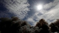 Matahari bersinar di atas kepulan asap kebakaran. REUTERS/Jose Luis Gonzalez.