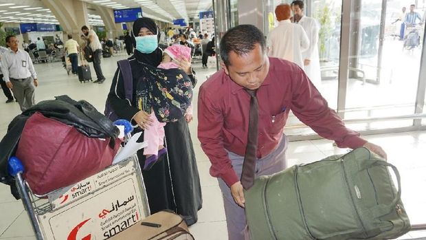 Petugas Yanlin KJRI menyiapkan bagasi untuk kepulangan Karimah beserta ibu dan kakaknya