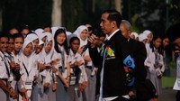 Jokowi mengenakan kemeja warna putih yang dilapisi jaket warna hitam bertuliskan Asian Games dan celana panjang warna hitam serta sepatu kets.Fotografer: Andhika Prasetia/detikcom