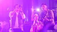 Saut meniup saxophone mengiringi lagu-lagu yang dibawakan Marjinal.