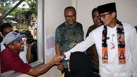 Seorang warga bersalaman dengan Sandiaga Uno.