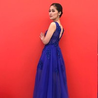Berpose di dinding merah, wanita 28 tahun tersebut mengenakan gaun biru tua nan kontras dari ExmeCouture. Foto: Instagram Gracia Indri