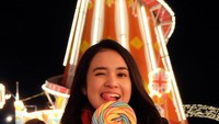 Hati-hati ya nanti gagal fokus. Sedang berkunjung ke Winter Wonderland @Hyde Park, Michelle Ziudith tak lupa mencicip permen lollipop. Foto: Instagram @michelleziu