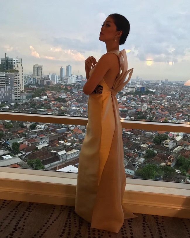 Berlatar belakang pemandangan kota Surabaya, anak sulung dari dua bersaudara ini memperlihatkan detail pita menarik di bagian punggung di gaun keluaran brand PRISZL tersebut. Foto: Instagram Gracia Indri