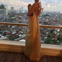 Berlatar belakang pemandangan kota Surabaya, anak sulung dari dua bersaudara ini memperlihatkan detail pita menarik di bagian punggung di gaun keluaran brand PRISZL tersebut. Foto: Instagram Gracia Indri