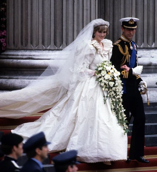 Gaun Putri Diana adalah gaun pengantin paling ikonik sepanjang masa. Gaun dirancang oleh pasangan suami istri, David dan Elizabeth Emanuel yang dibuat dari silk ivory, tafetta dan lace antik milik Ratu Mary. Gaun ini begitu terkenal karena memiliki train yang sangat panjang, begitu juga bagian veilnya. Foto: dok. Time