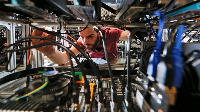 Employees work on bitcoin mining computers at Bitminer Factory in Florence, Italy, April 6, 2018. Picture taken April 6, 2018. REUTERS/Alessandro Bianchi
