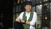 Dengan mengenakan topi, syal, dan sepatu berujung runcing, Saut siap tampil di Konser Perangi Korupsi.