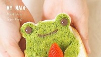 Kali ini rotinya diolesi dengan selai matcha homemade. Dengan bentuk katak berwarna hijau plus mata dan mulut. Sambil memegang buah strawberry sajian ini snagatlah unik. Foto: Instagram @songsweetsong