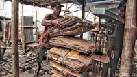 Seorang nelayan tengah menimbang kardus.