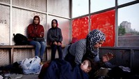 Seorang gadis kecil tertidur dipangkuan sang ibu, sementara sang ibu berusaha mengusir nyamuk agar tidak mengganggu tidur anaknya. Alkis Konstantinidis/Reuters.