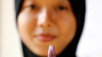 Seorang anggota militer wanita menunjukkan jari kelingkingnya setelah melaksanakan Pemilu. Lai Seng Sin/Reuters.