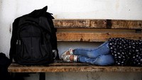 Panjangnya jalur yang harus ditempuh oleh para imigran membuat banyak diantara mereka, khususnya anak kecil kelelahan hingga tertidur saat sedang menunggu truk polisi yang akan mengangkut mereka. Alkis Konstantinidis/Reuters.