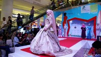 Seorang model berjalan di atas catwalk untuk memamerkan busana muslim.
