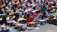 Para siswa sibuk menggoreskan pensil di atas kertar gambar.