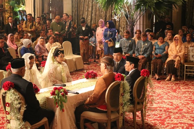 Akad nikah Sekar dengan Ajie Sulistyo Dwi Putra Maryulis digelar di ballroom Hotel Kempinski, Jakarta Pusat. Area ballroom untuk akad nikah ini berbeda dengan tempat resepsi. Untuk akad nikah, ballroom hotel dihiasi gebyok kayu dan emas serta dominasi bunga berwarna merah. Foto: istimewa