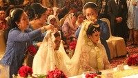 Titiek Soeharto yang berkebaya warna biru terlihat ikut memasangkan kain ke kepala kedua mempelai.