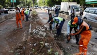 Usai dievakuasi, petugas PPSU langsung membersihkan puing sisa kecelakaan.