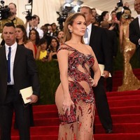 Bukan Jennifer Lopez namanya jika tak tampil menantang. Gaun merah Versace yang hampir mengekspos bokongnya menjadi pilihan aktris dan penyanyi berdarah Latin itu. (Foto: Getty Images)