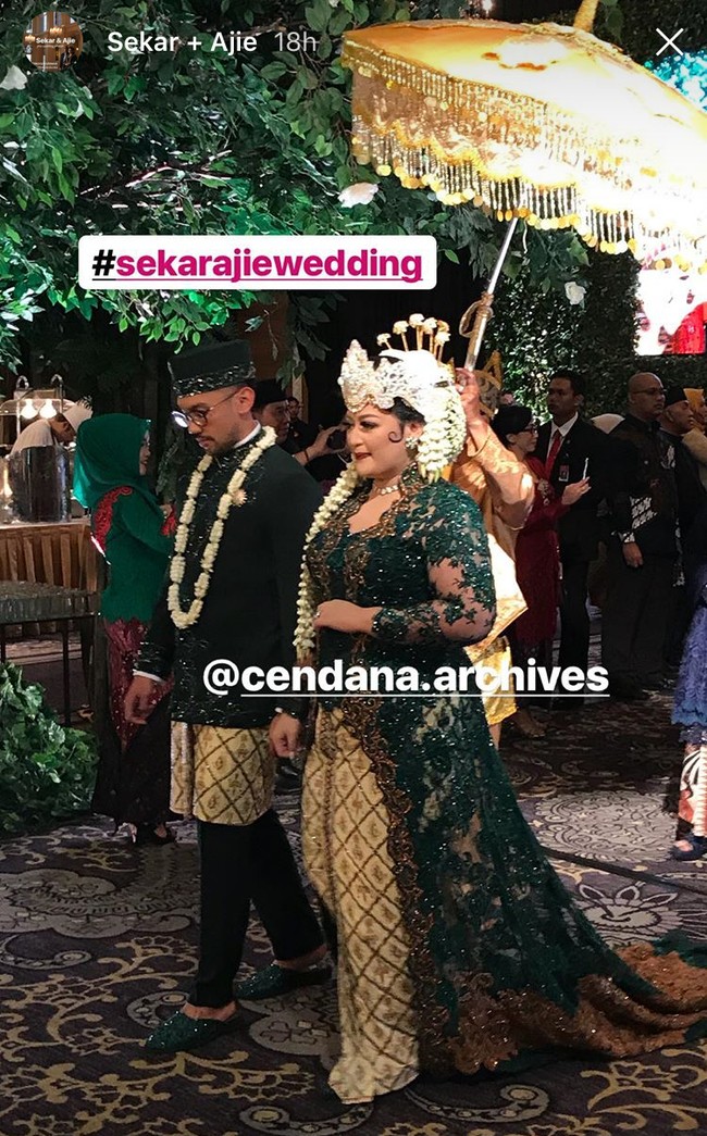 Inilah penampilan Sekar dan Ajie saat resepsi pernikahan mereka yang digelar mewah di Hotel Kempinski, Jakarta, Minggu (6/5/2018) malam. Kedua mempelai berganti busana. Jika saat akad nikah memakai adat Jawa, ketika resepsi menjadi adat Sunda. Sang pengantin wanita memakai kebaya hijau lumut yang panjangnya menyapu lantai. Sekar juga mengenakan mahkota dan hiasan kepala seperti pengantin Sunda. Foto: Instagram/Cendana Archives