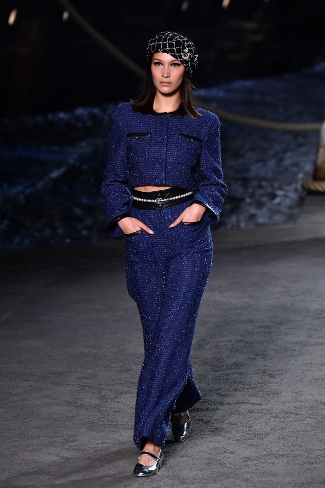 Tampak Bella Hadid turut masuk dalam barisan model pilihan Karl. Adik dari Gigi Hadid itu menebar pesonanya dengan cropped blouse biru dan celana lebar senada. Foto: Pascal Le Segretain/Getty Images for Chanel