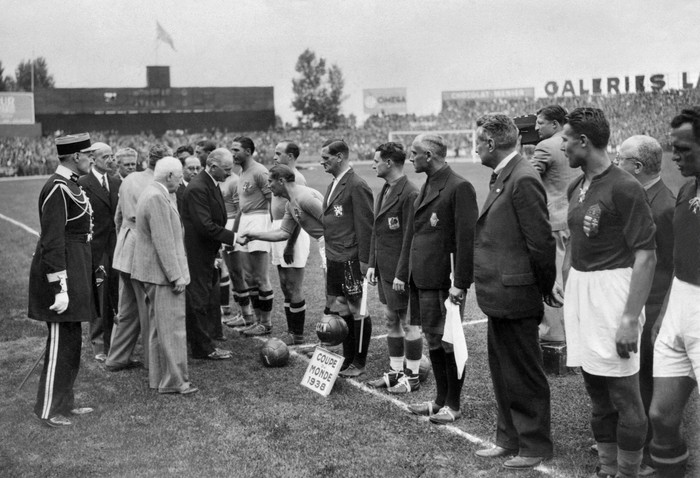 French president Albert Lebrun (C, dark suit), standing next to the French president of the FIFA, Jules Rimet (white hair), shakes hand with Italian national soccer team captain Giuseppe Meazza, 19 June 1938 in Colombes, in the suburbs of Paris, before the start of the World Cup final between Italy and Hungary,. (2nd right is Hungarian captain Gyorgy Sarosi)  AFP PHOTO / AFP PHOTO / STAFF