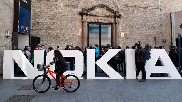FILE PHOTO: A cyclist rides past a Nokia logo during the Mobile World Congress in Barcelona, Spain February 25, 2018. REUTERS/Yves Herman