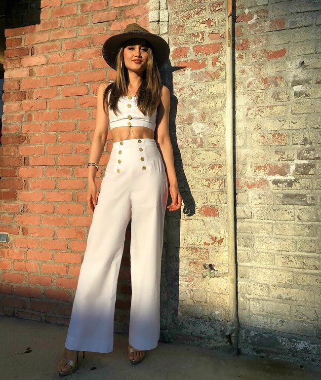 Bergaya formal namun tetap seksi, itulah penampilan Cinta Laura dalam balutan crop top dan celana berpotongan lebar ini. Bintang film 24 tahun itu menambahkan topi pada penampilannya dibalut brand Mumu. Foto: Dok. Instagram Cinta Laura