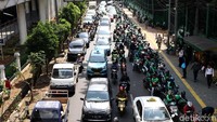 Driver ojek online memarkirkan motornya di pinggir jalan depan Stasiun Palmerah, Jakarta, Senin (7/5/2018).