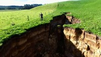 Lubang menganga ini muncul di area peternakan wilayah Rotorua di North Island, sejak pekan lalu. Lubang menganga ini muncul setelah hujan deras mengguyur kota Rotorua. Foto: AFP/TVNZ