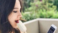 Hmm, sambil duduk santai pemilik nama asli Olivia Lubis Jensen sedang asyik menikmati es krim dan melihat gadgetnya. Foto: Instagram @oliviajensen