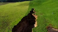 Salah satu pekerja di peternakan itu merupakan orang pertama yang menemukan keberadaan lubang menganga ini. Lubang menganga ini dilaporkan memiliki panjang 200 meter dan lebar 20-30 meter dengan kedalaman 20 meter. Foto: AFP/TVNZ