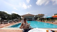 Minggu pagi memang paling enak untuk bersantai. Pangeran Mateen memilih duduk di tepi kolam renang sambil baca koran dan sarapan. Foto: Instagram tmski