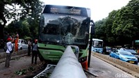 Terlihat kaca depan Bus TransJ retak.