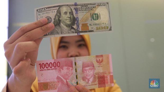 Ilustrasi Rupiah dan Dollar di teller Bank Mandiri, Jakarta, Senin (07/5). Nilai tukar rupiah terhadap dolar Amerika Serikat (AS) masih melemah. Rupiah melemah 0,32 % dibandingkan penutupan akhir pekan lalu. Harga jual dolar AS di  bank Mandiri Rp. 14.043. (CNBC Indonesia/Muhammad Sabki)