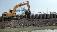 Alat berat eksavator menyelesaikan proyek tanggul pengaman pantai di kawasan Kali Baru, Cilincing, Jakarta Utara, Senin (7/5).